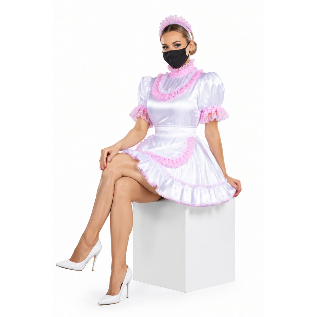 White sissy maid dress with pink lace trim, ruffled collar, and matching headband, styled with white heels.