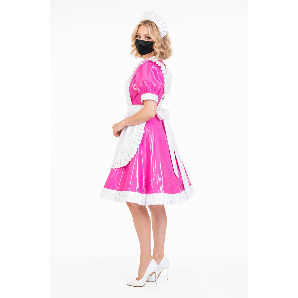 Pink PVC sissy maid dress with white apron, frills, and matching hat, styled with white heels.