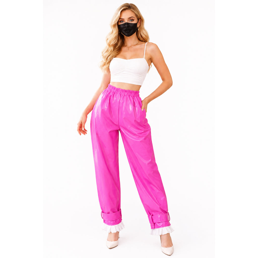 Bright pink PVC pants with white ruffles, paired with white crop top and heels