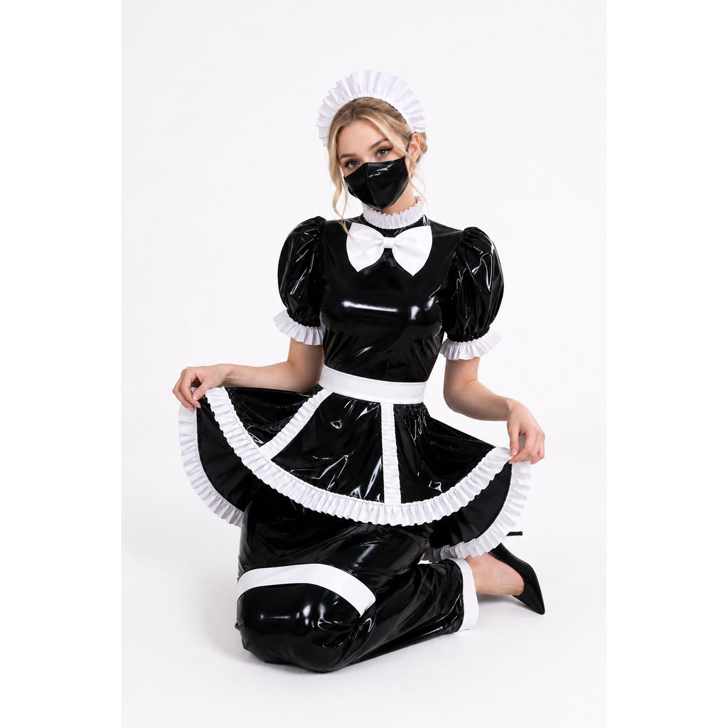 Black PVC sissy maid dress with white ruffles, bow, and matching hat, worn by model kneeling on white background.