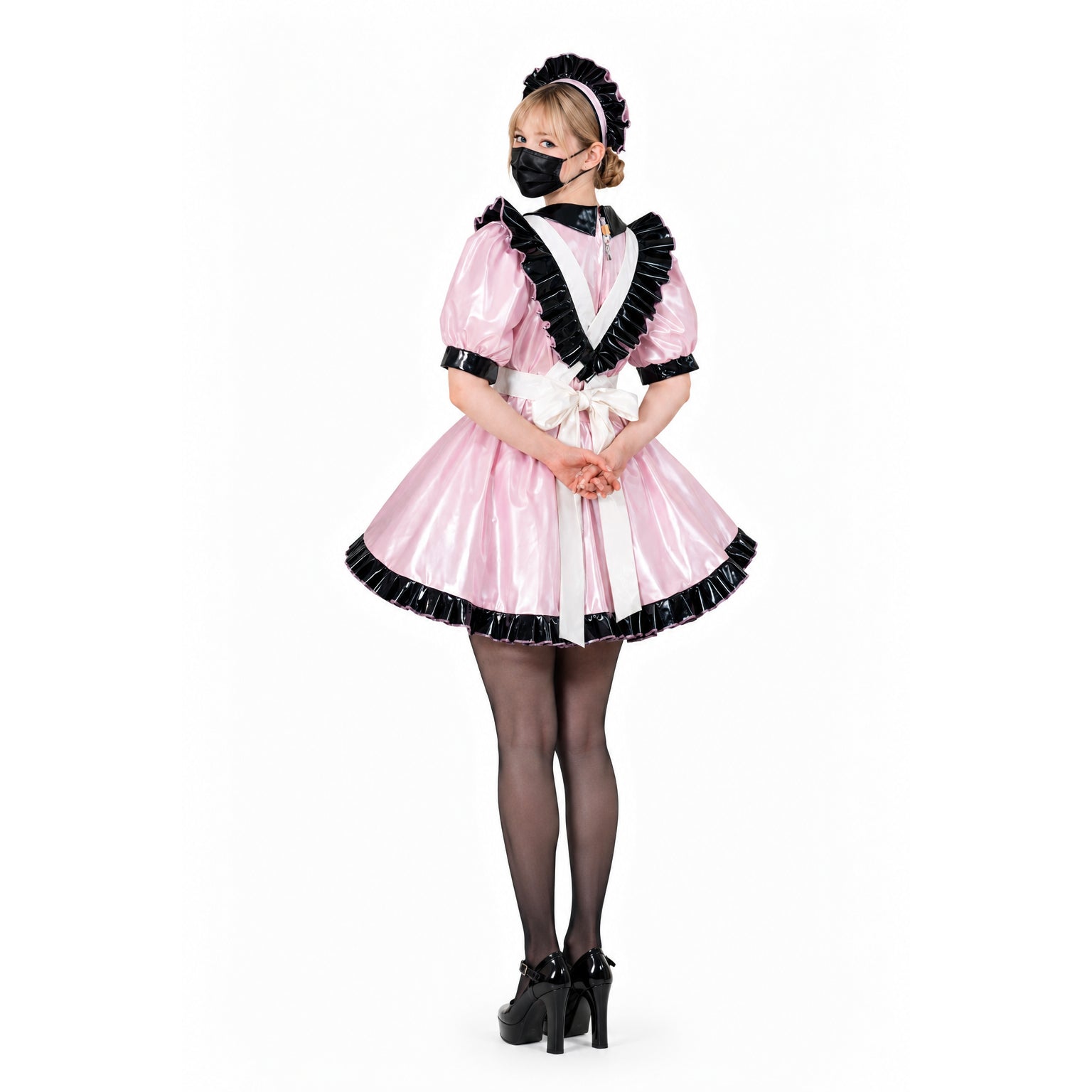 Pink sissy maid dress with black ruffles, white apron, and matching bonnet, styled with heels and stockings.