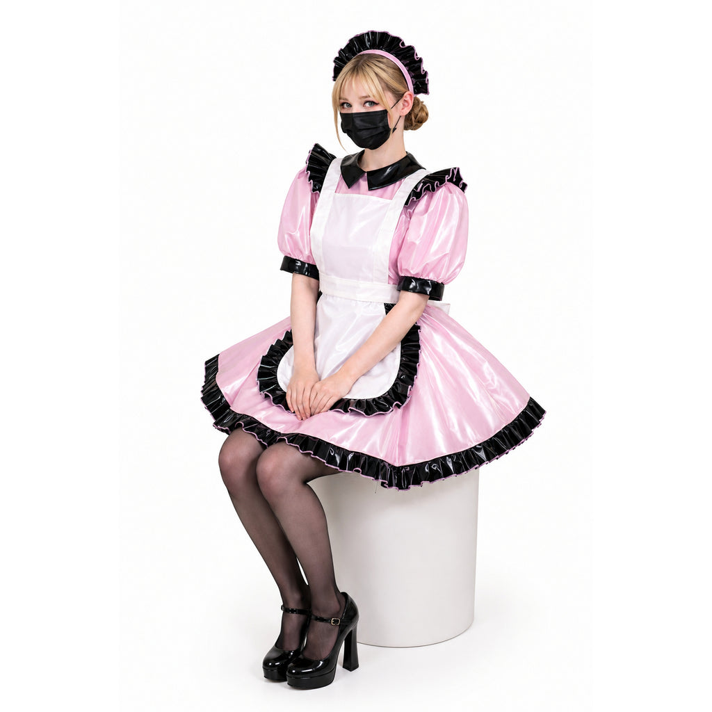 Pink sissy maid dress with black ruffles, PVC apron, and matching headband, styled with heels and stockings