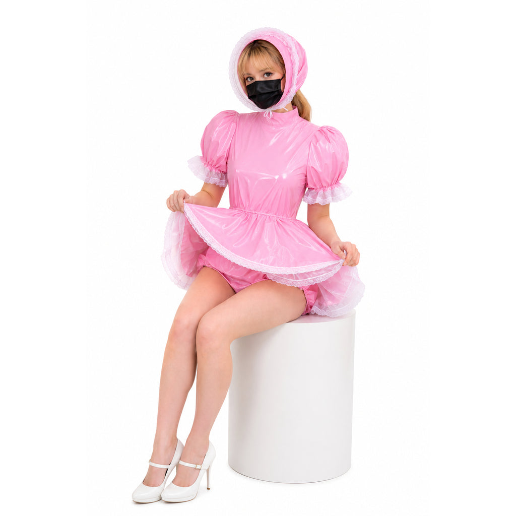 Pink PVC sissy maid dress with lace trim, hood, and matching panties, styled with white heels