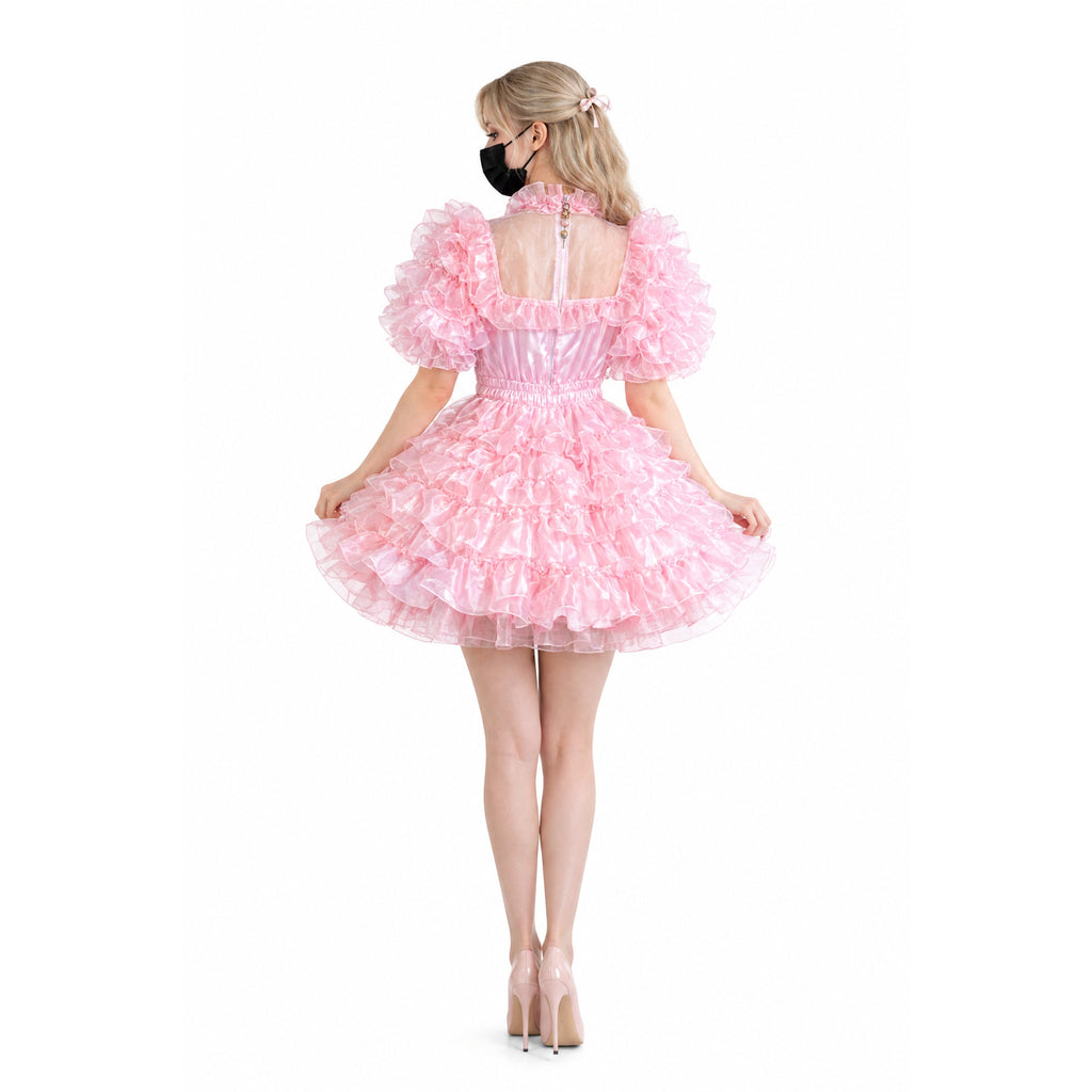 Pink ruffled sissy maid dress with sheer back, puffy sleeves, and layered skirt, worn with heels