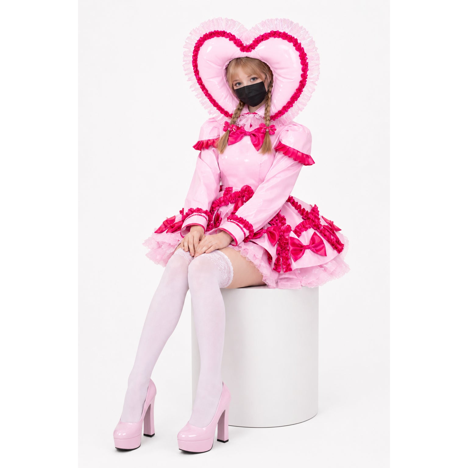 Pink sissy maid dress with heart-shaped hood, ruffles, and bows, paired with thigh-high stockings and platform heels