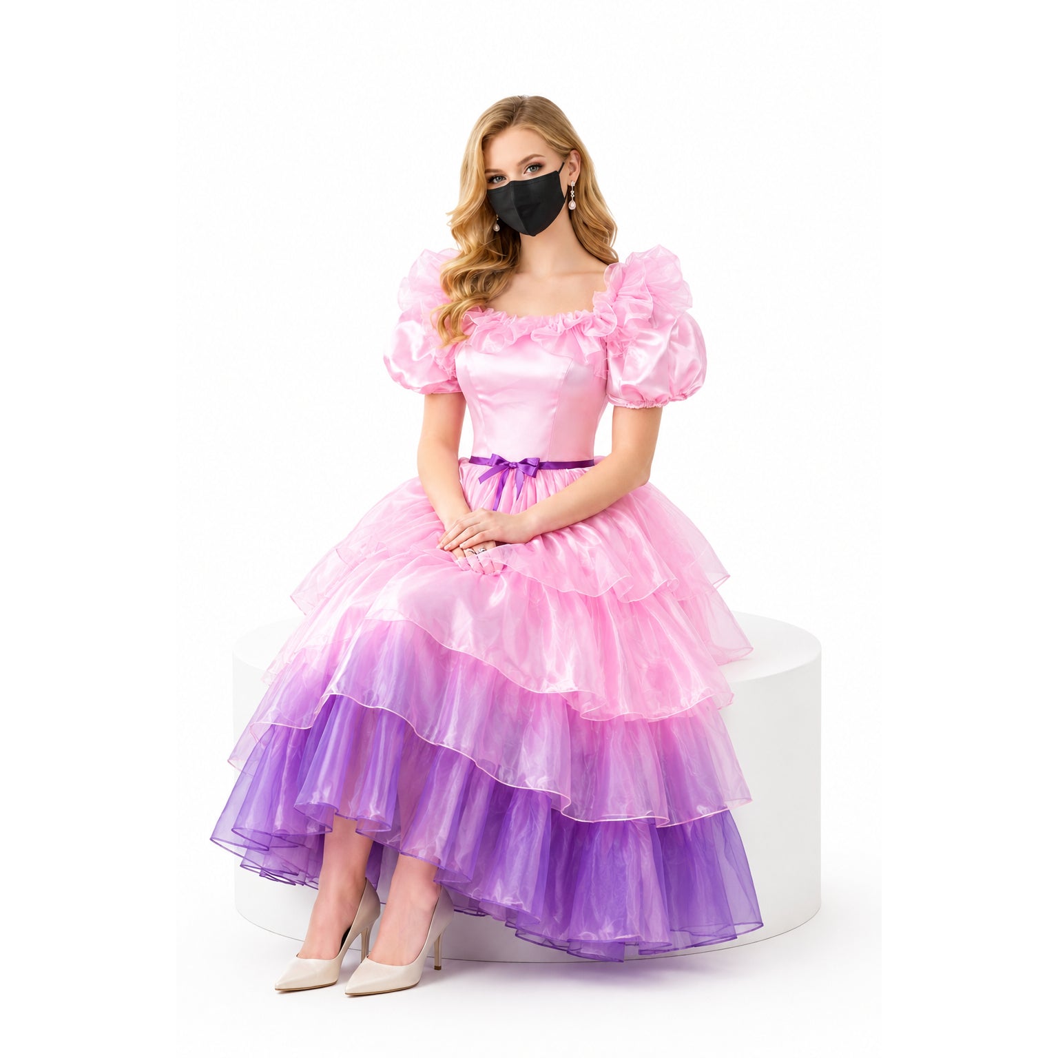 Pink and purple layered sissy maid dress with puffed sleeves and ruffles, worn by seated model