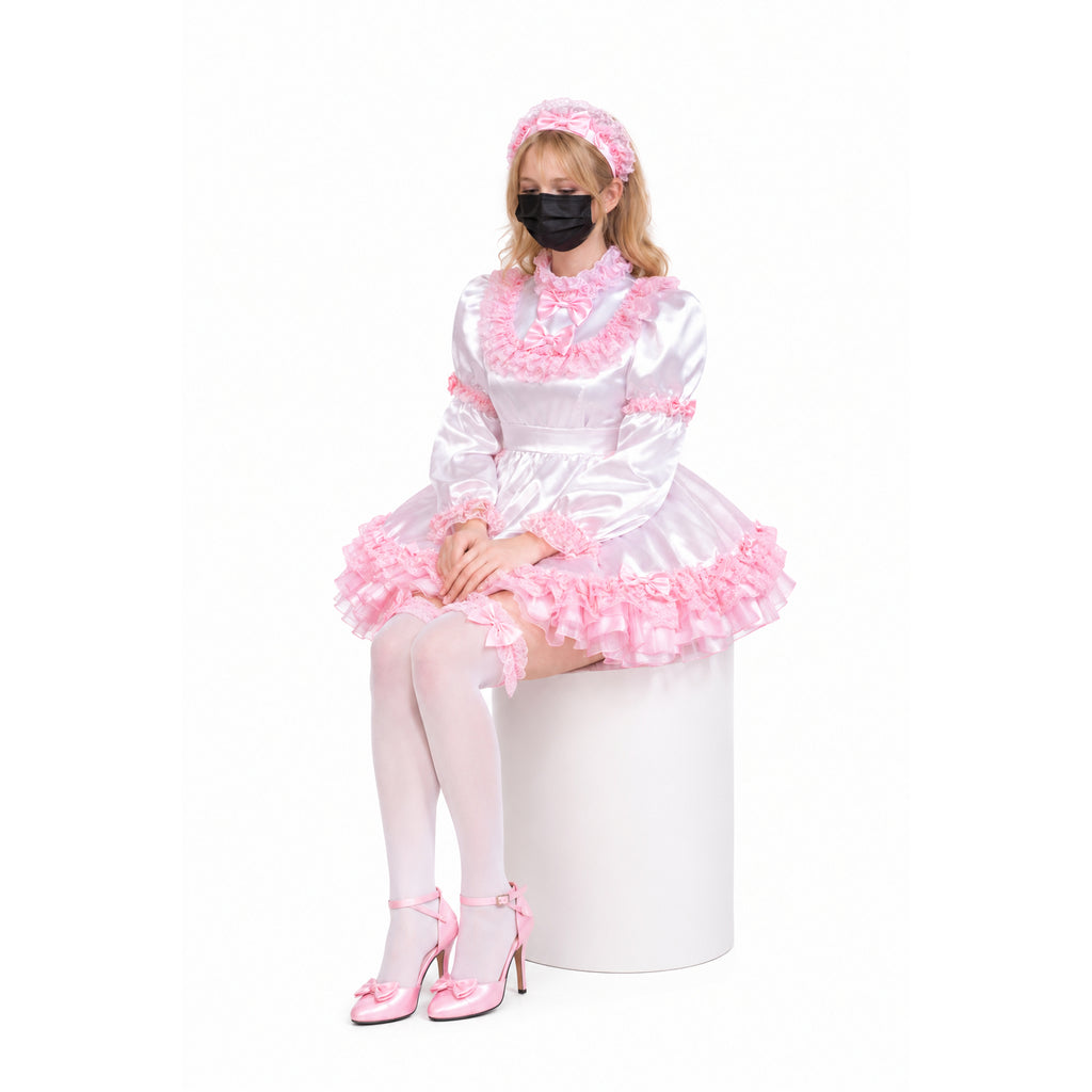 Pink sissy maid dress with ruffles, bow accents, and matching headband, worn with white stockings and heels.