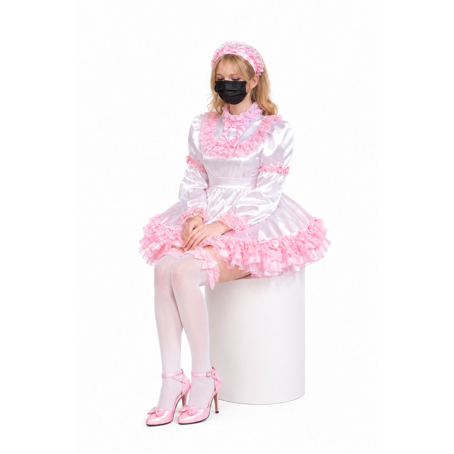 Pink sissy maid dress with ruffles, bow accents, and matching headband, worn with white stockings and heels.
