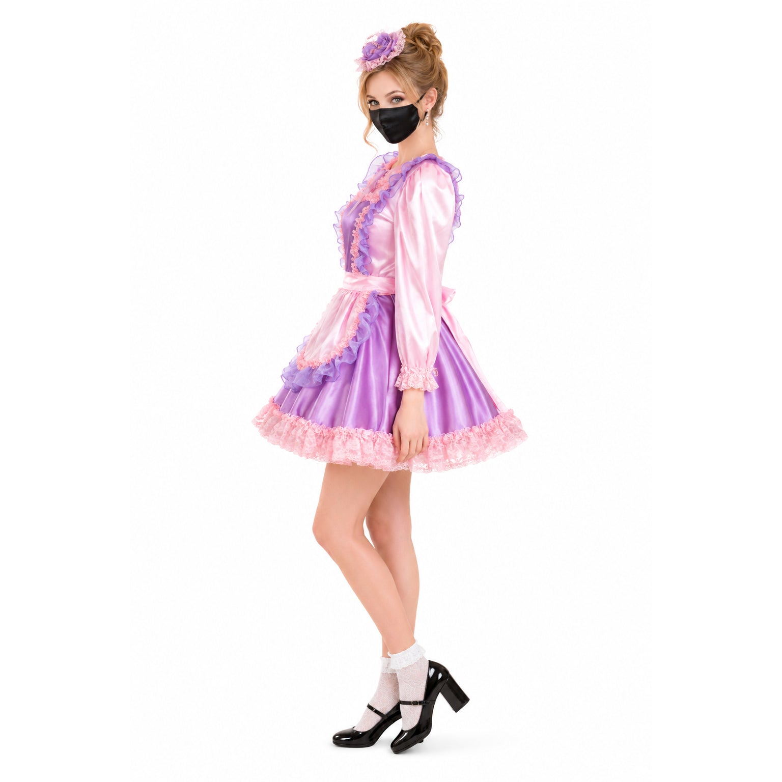 Pink and purple sissy maid dress with ruffles, lace trim, and matching headpiece, styled with black heels and mask.