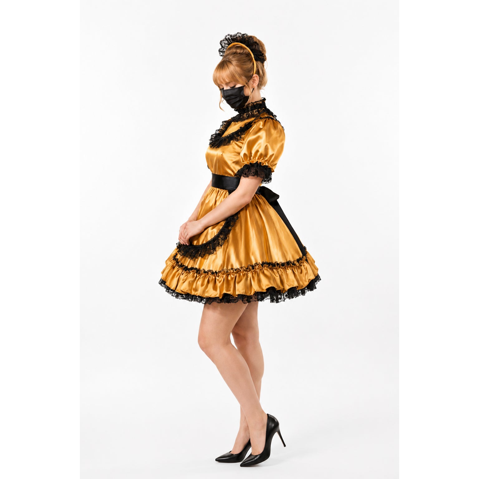Golden sissy maid dress with black lace trim, satin fabric, and ruffled skirt, styled with heels and headpiece.
