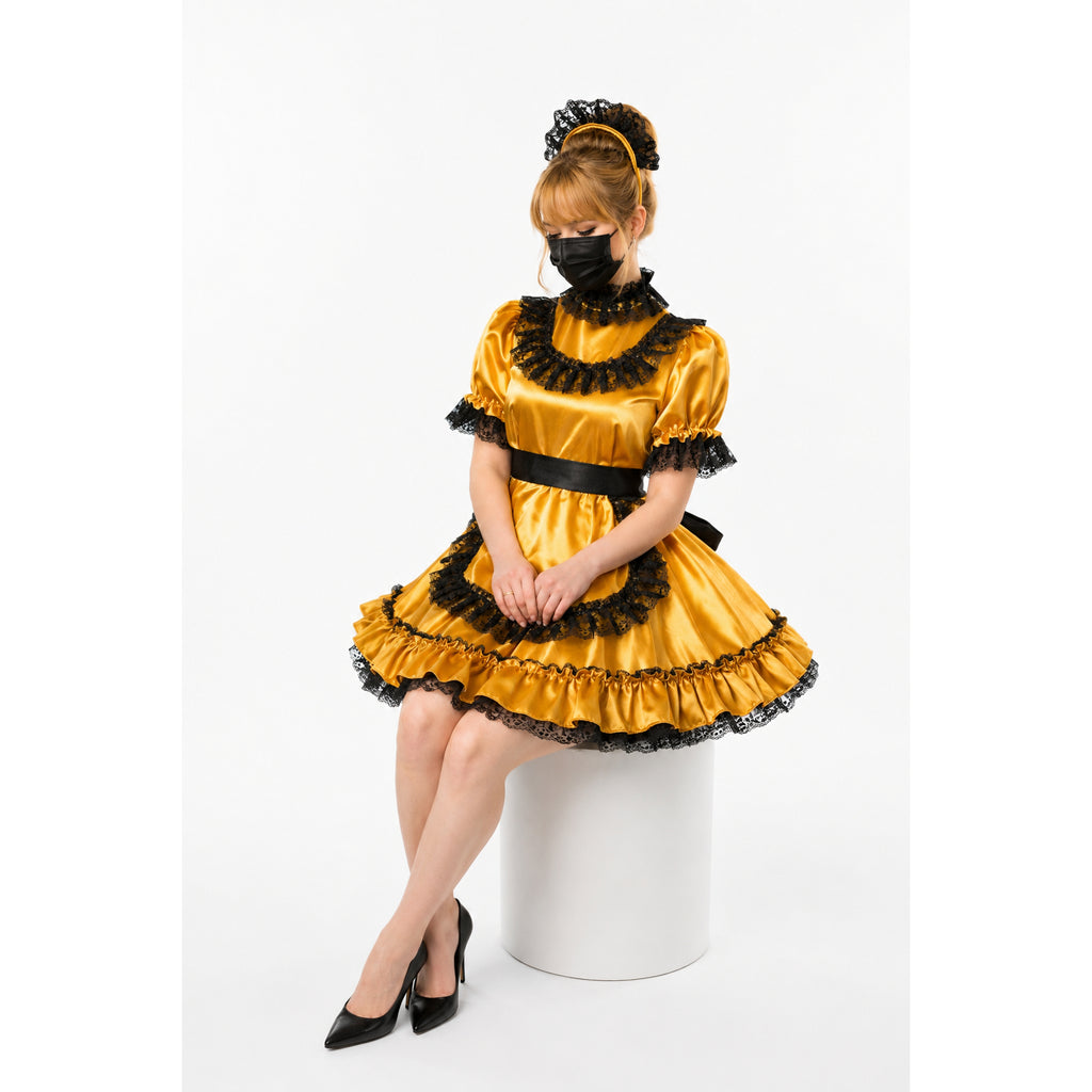Gold sissy maid dress with black lace trim, satin fabric, and ruffled skirt, styled with heels and headpiece.
