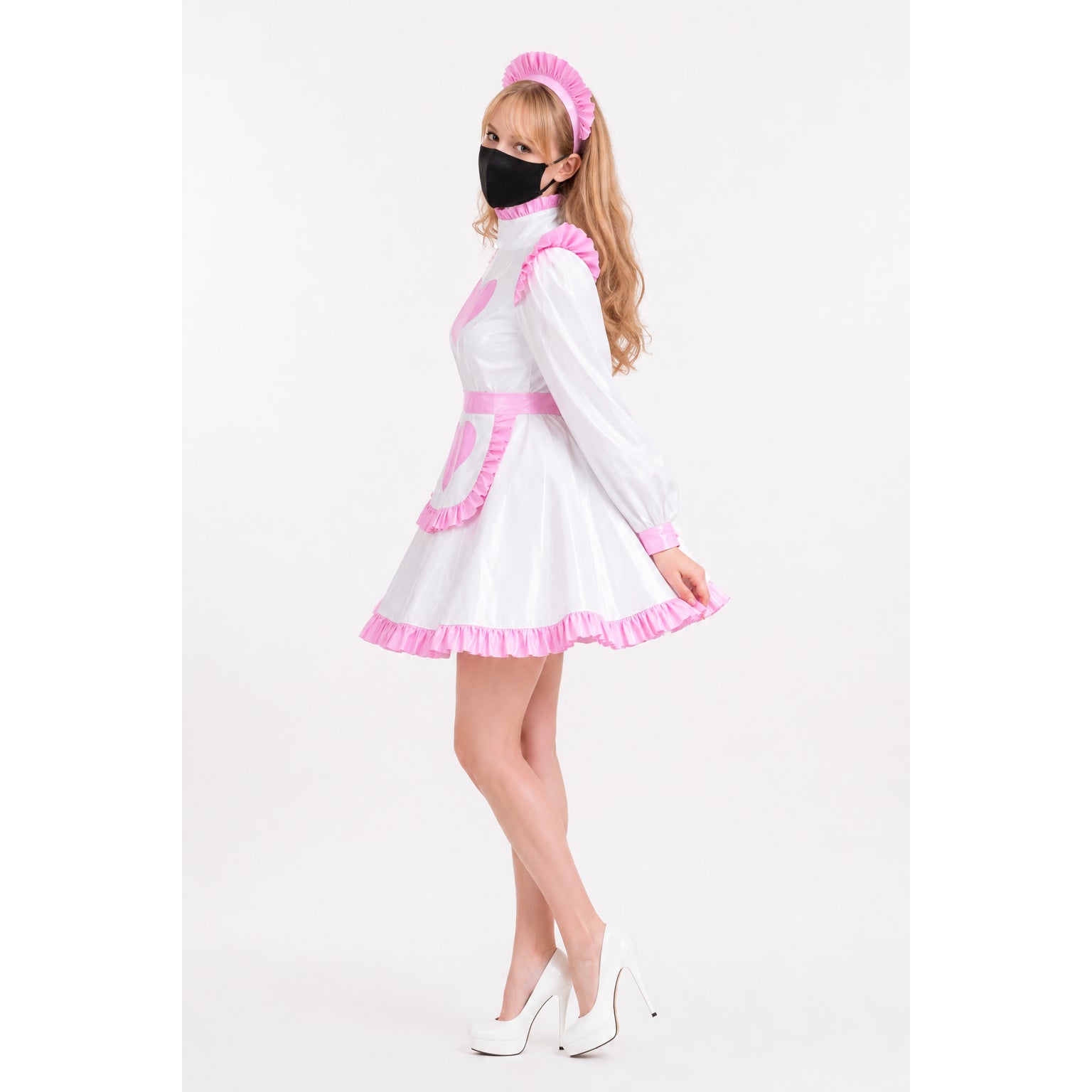 White and pink sissy maid dress with ruffles, apron, and headband, paired with white heels