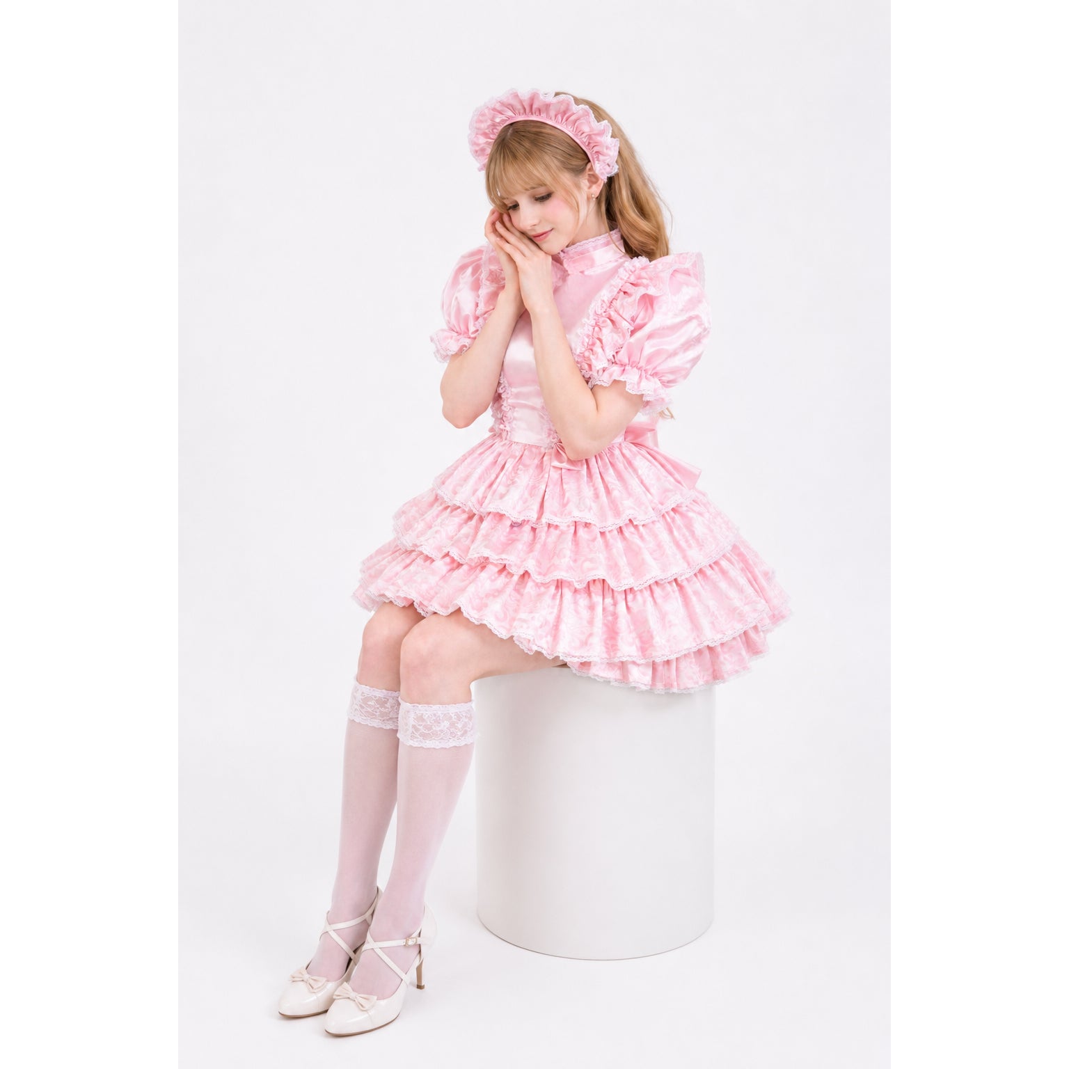 Pink sissy maid dress with ruffles, lace trim, and matching headband, styled with white heels and thigh-highs