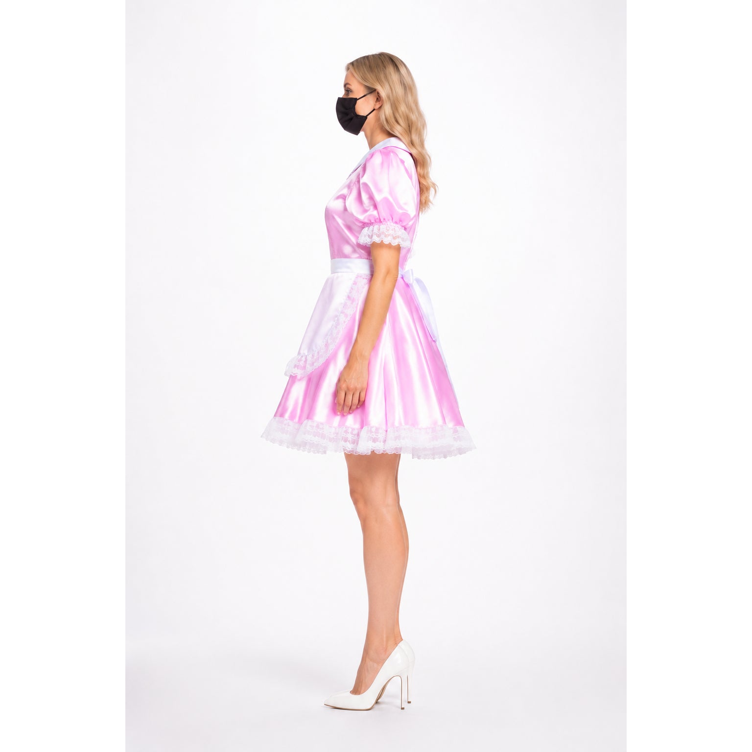 Pink satin sissy maid dress with white lace trim and bow, styled with white heels