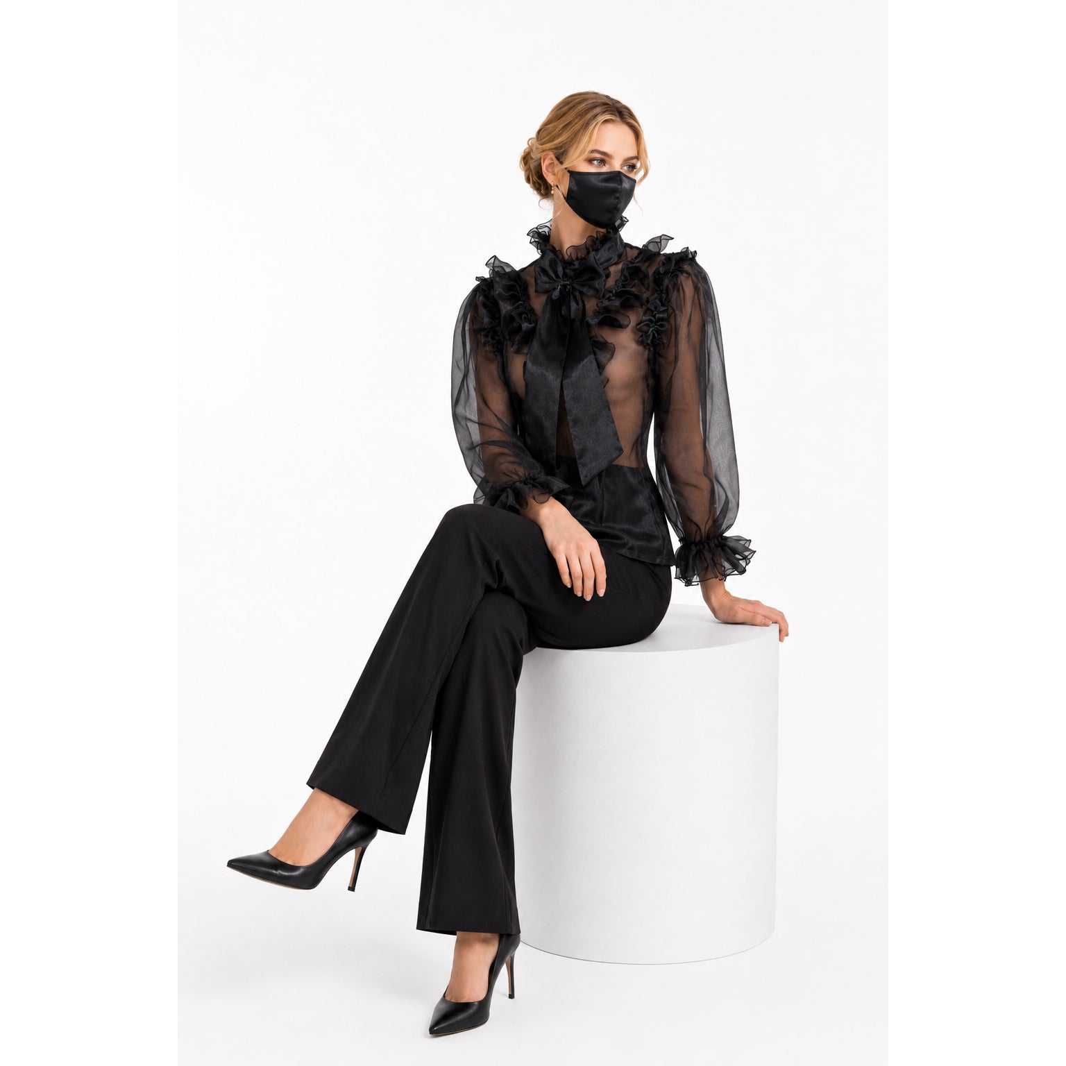 Black sheer ruffle blouse with bow, paired with wide-leg pants and heels, elegant fashion set