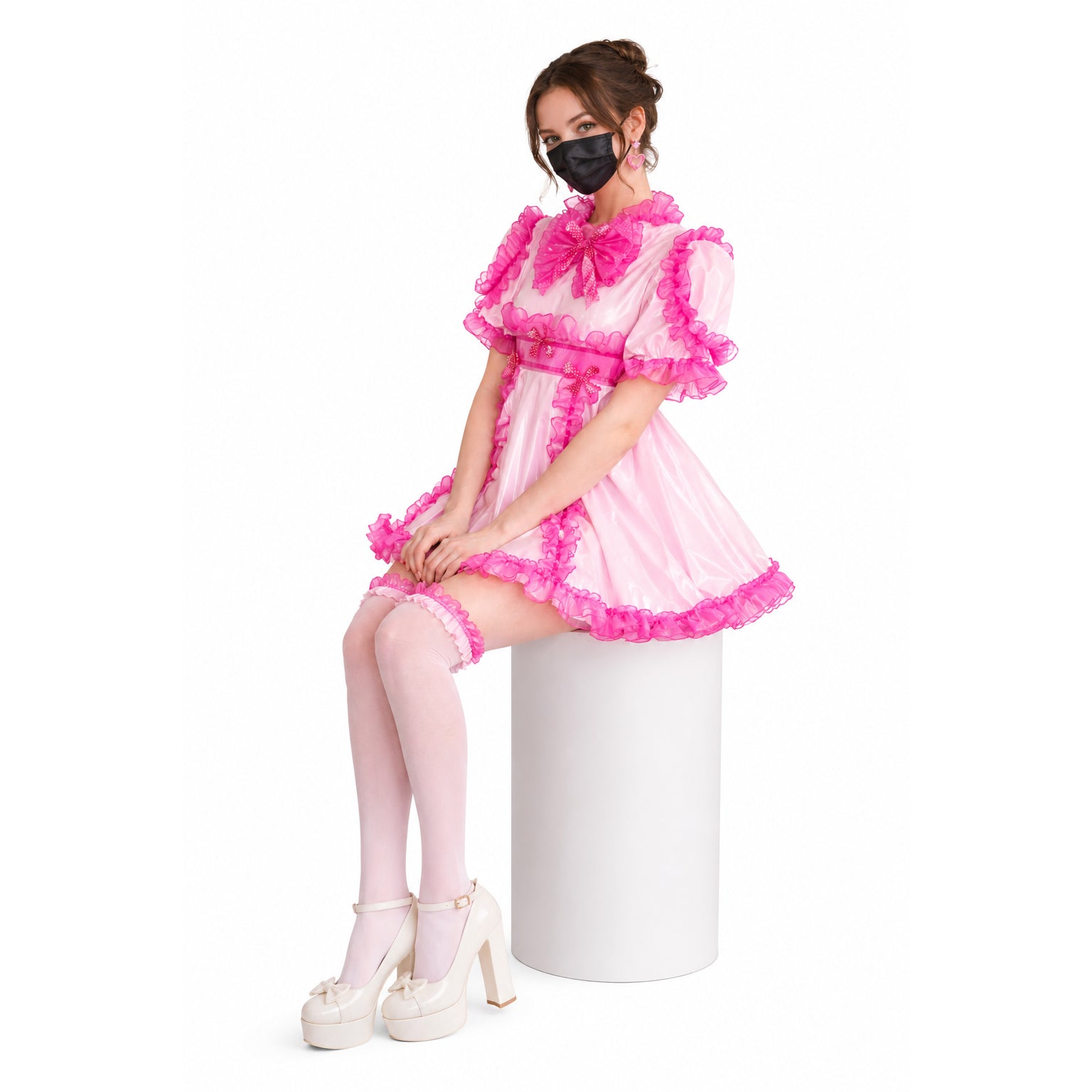 Pink sissy maid dress with ruffles, bow, and matching thigh highs, styled with platform heels.