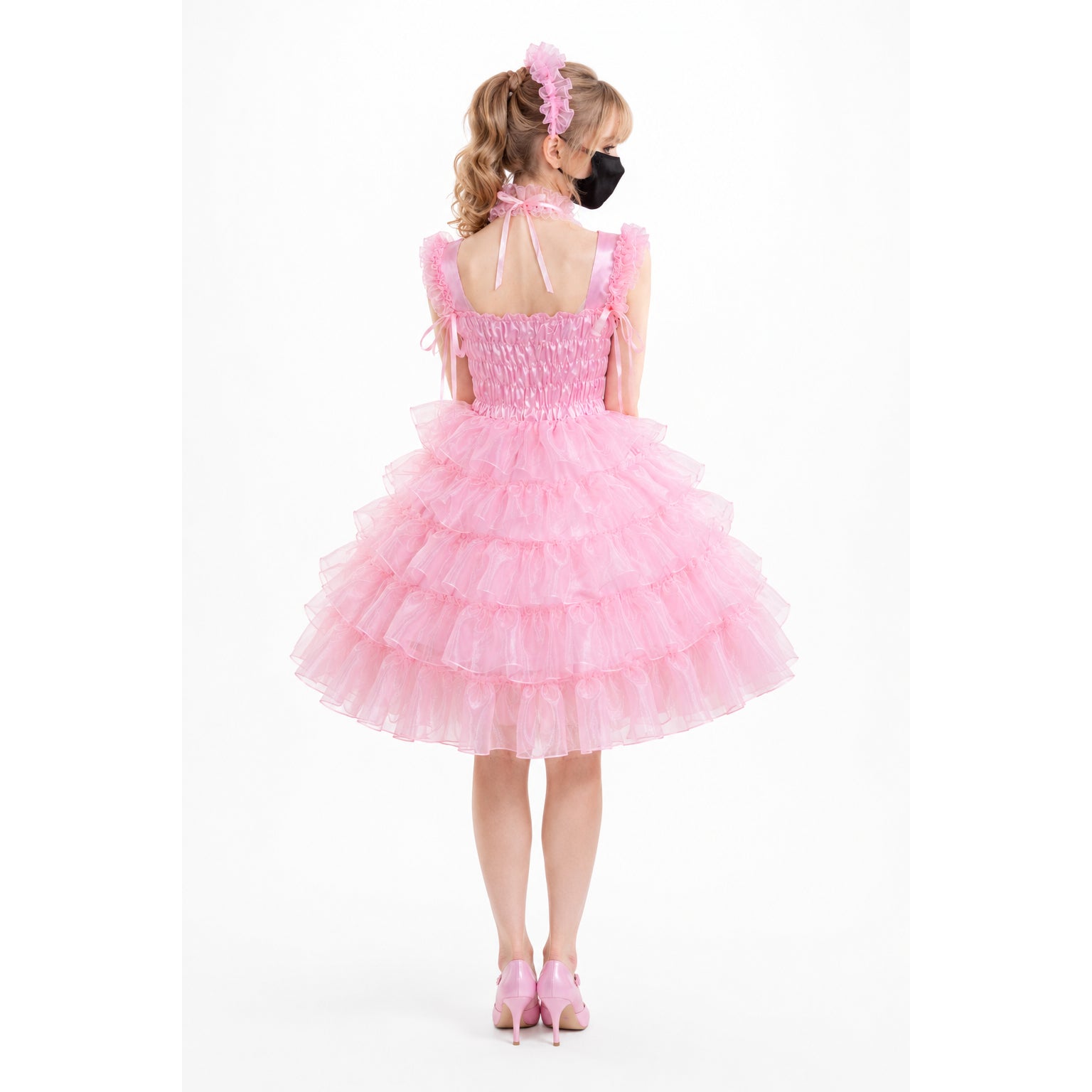 Pink sissy maid dress with ruffled tulle skirt, bow straps, and matching heels, shown from back
