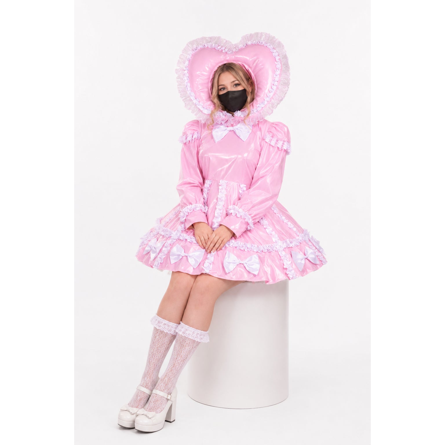 Pink sissy maid dress with heart hood, ruffles, and bows, paired with lace socks and platform heels