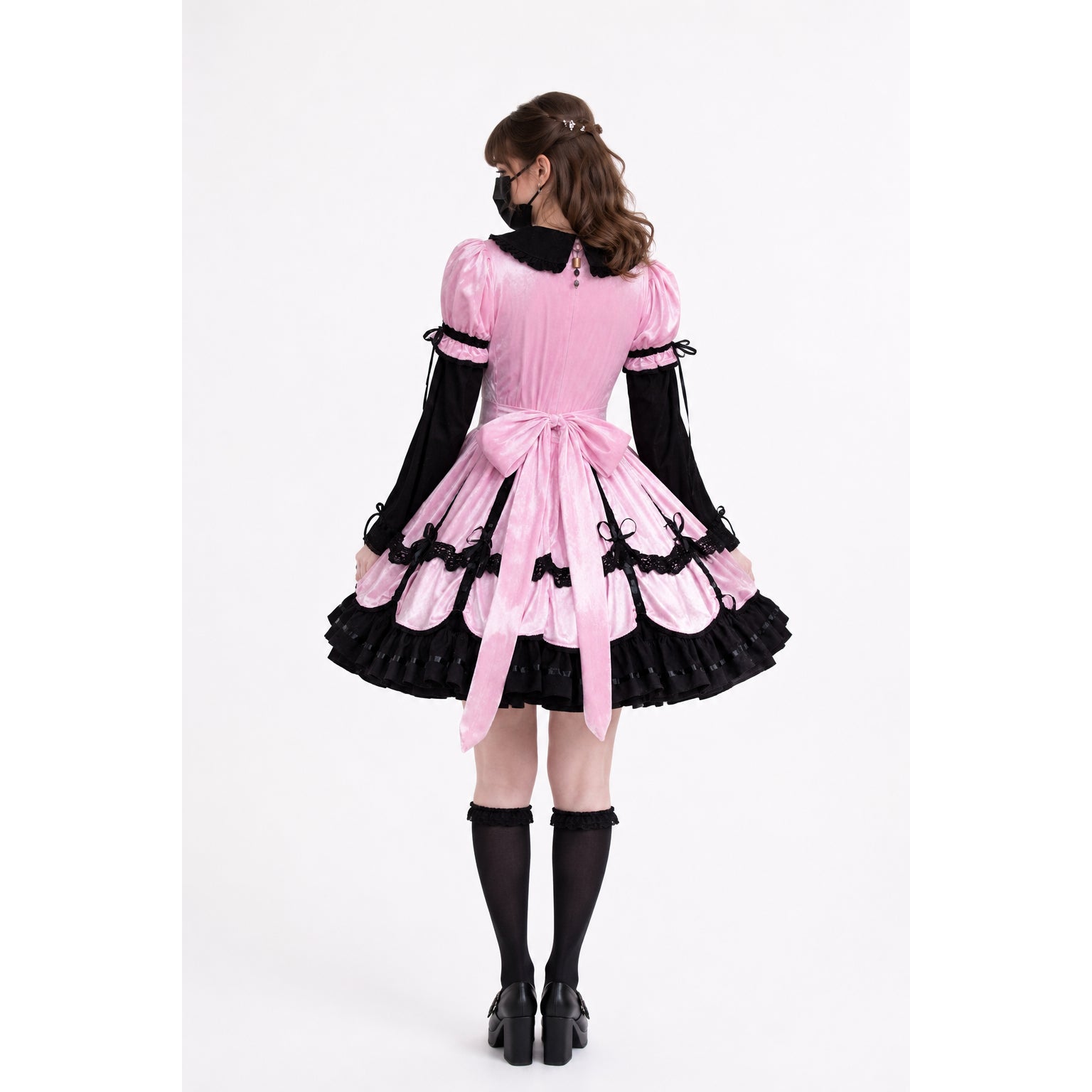 Pink sissy maid dress with black lace, bow, and ruffles, shown from back