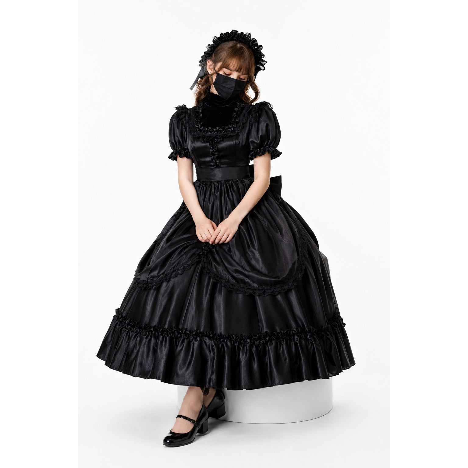 Black sissy maid dress with ruffles, puff sleeves, and satin finish, styled with matching headpiece and heels