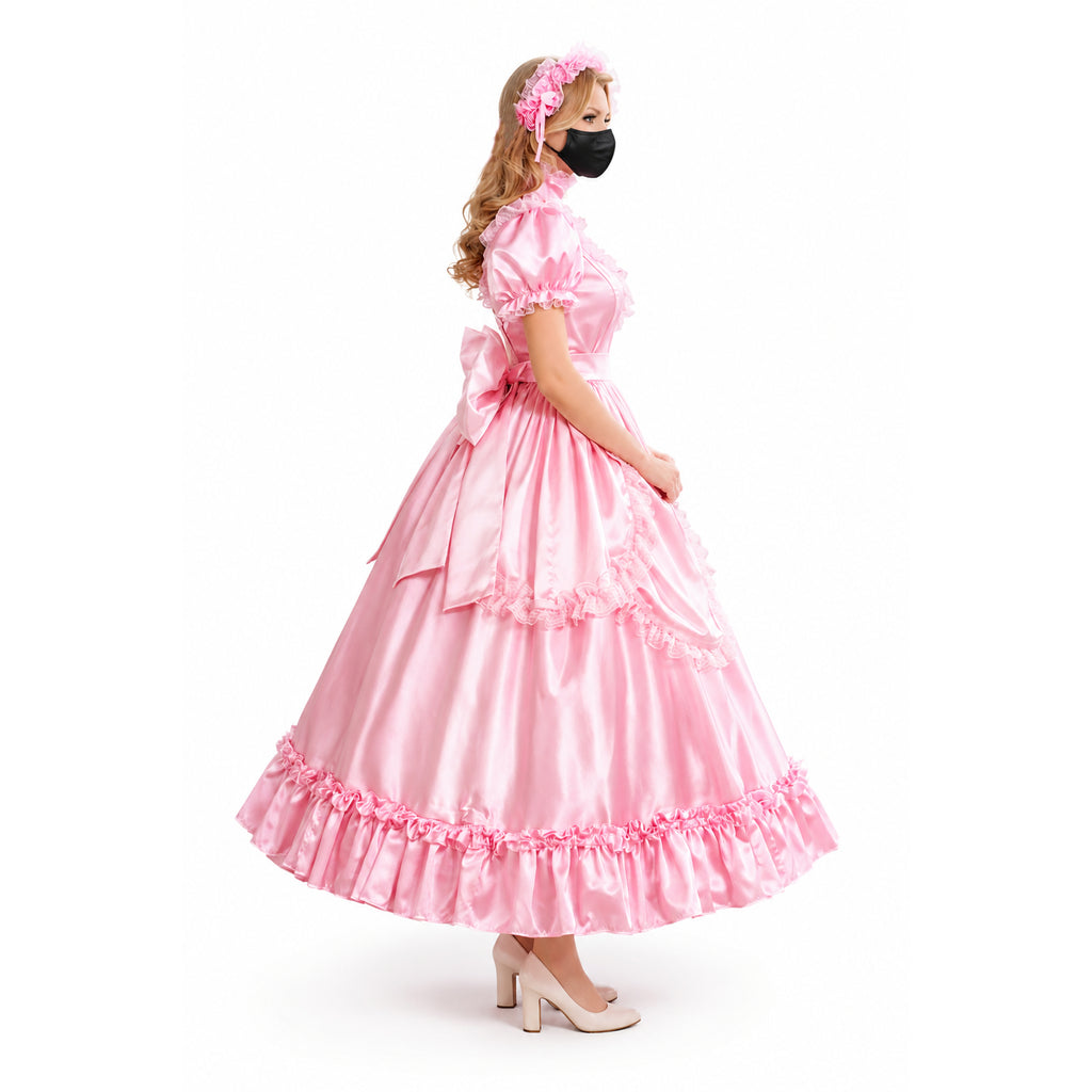 Pink sissy maid dress with ruffles, bow, and floral headband, worn with heels and face mask