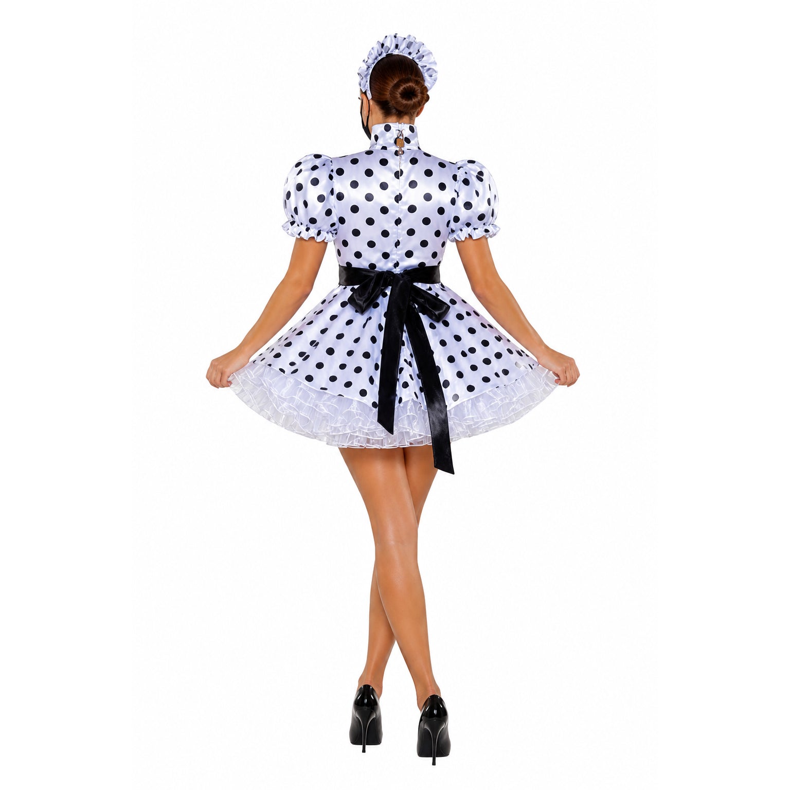 Polka dot sissy maid dress with black bow, ruffled hem, and matching headpiece, worn with high heels.