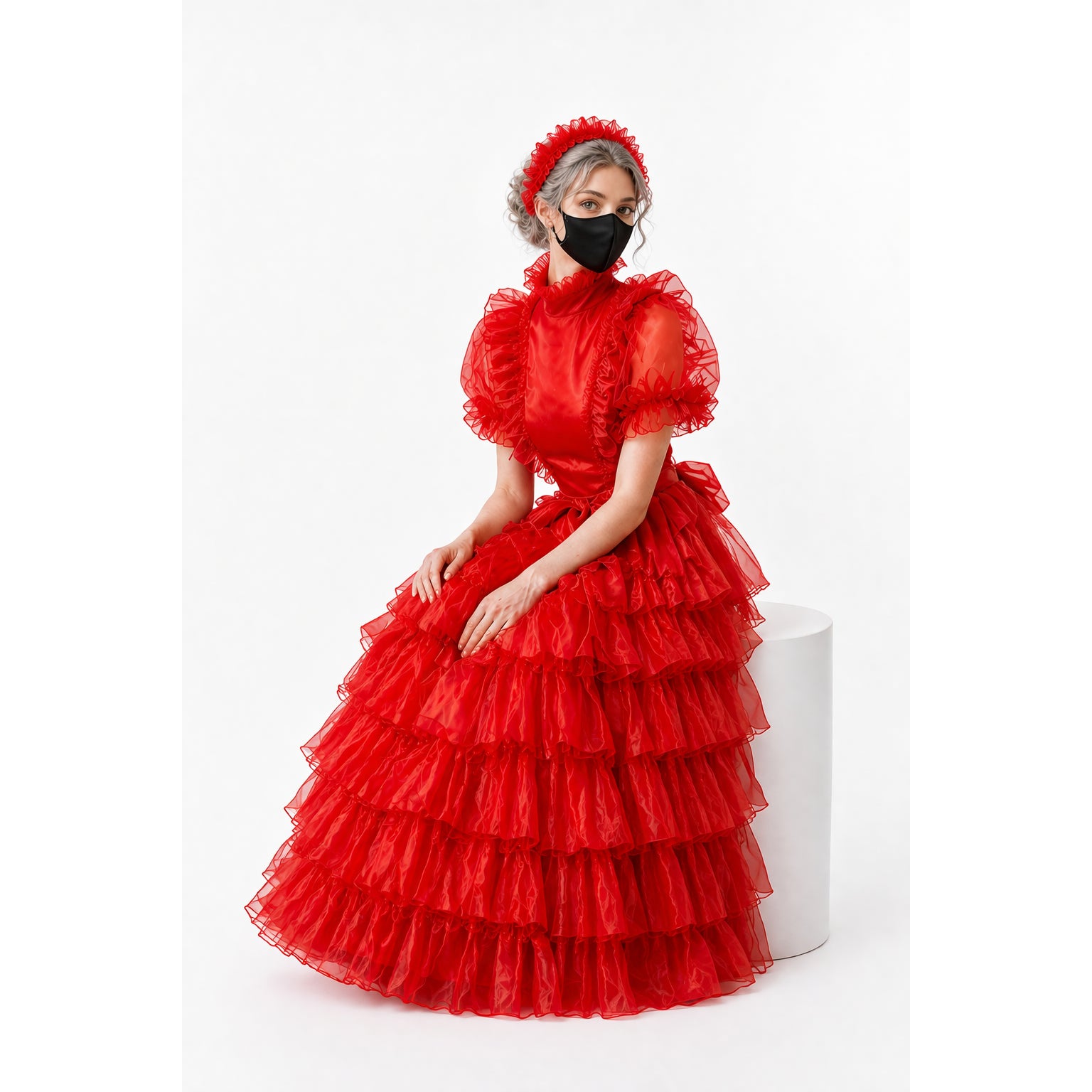 Red ruffled sissy maid dress with layered tulle skirt and matching headband, worn by model on white pedestal.