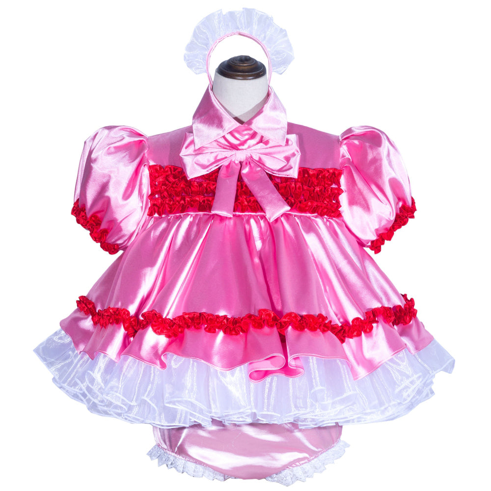 Pink sissy maid dress with red ruffles, white petticoat, and matching headpiece on mannequin