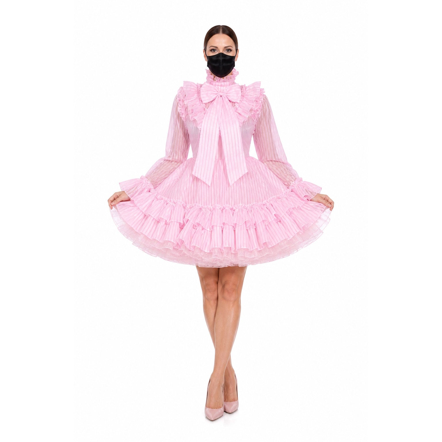 Pink sissy maid dress with ruffles, bow, and sheer sleeves, styled with heels and face mask