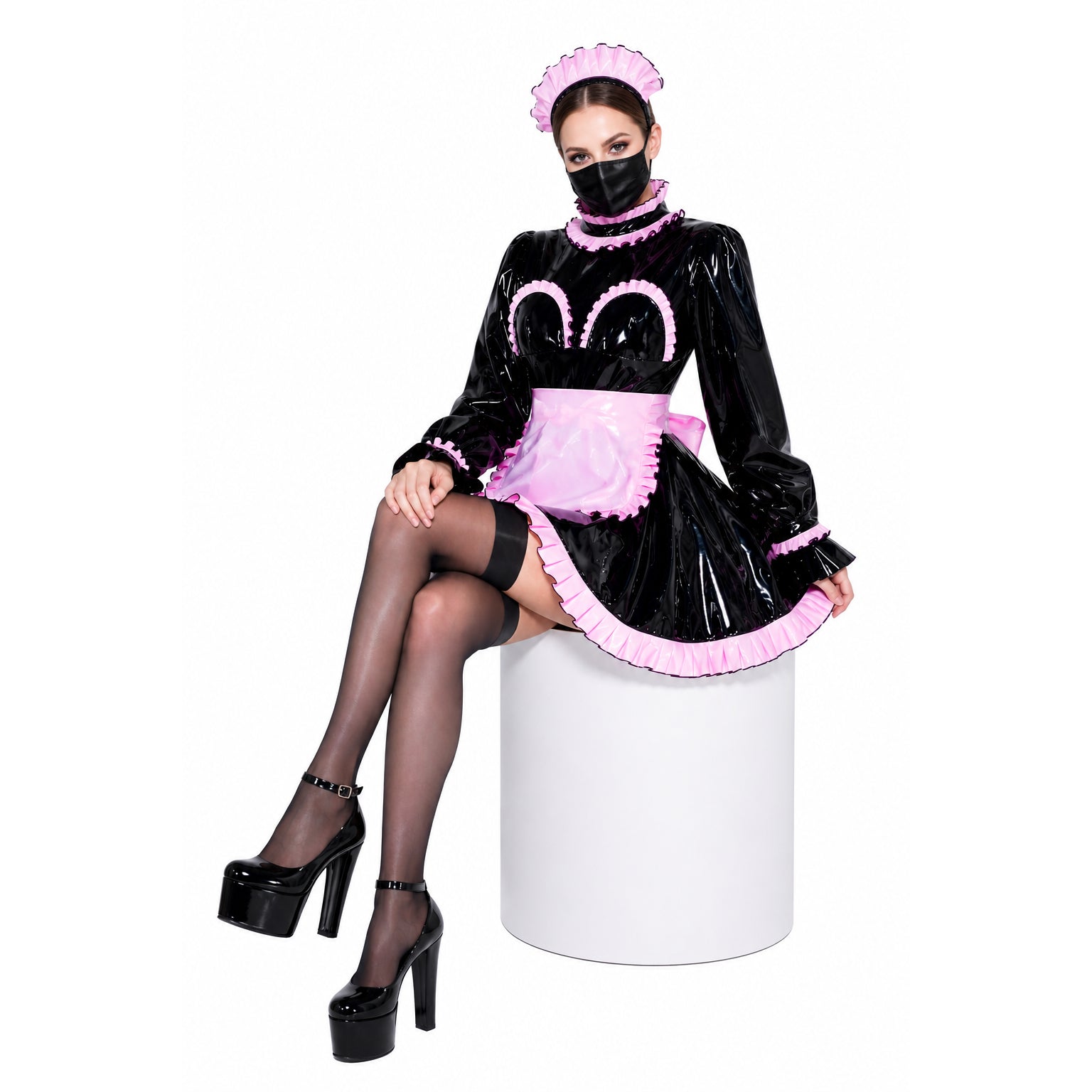 Black PVC sissy maid dress with pink ruffles, apron, and matching hat, paired with platform heels.